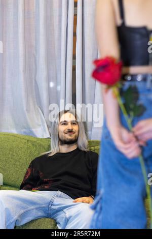 Una coppia felice godendo un momento di relax insieme su un comodo divano, ridendo e interagendo tra loro Foto Stock