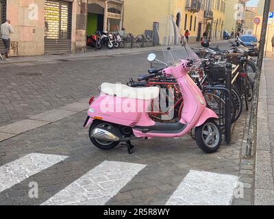 Cremona, Italia - Maggio 2023 Moto Vespa rosa parcheggiato per le strade della città Foto Stock