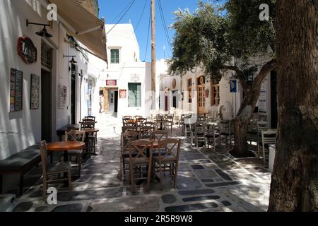 IOS, Grecia - 21 maggio 2021 : Vista di un vicolo tipico con bar, negozi e la chiesa cattedrale nella pittoresca isola di iOS Grecia Foto Stock