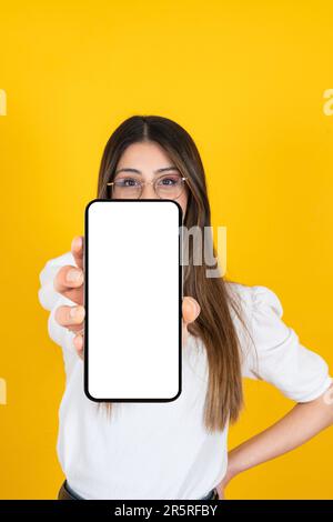 Ritratto di ragazza caucasica che mostra vuoto bianco schermo smartphone raccomandare. Tenere il telefono cellulare con spazio per la copia per il mockup. Foto Stock