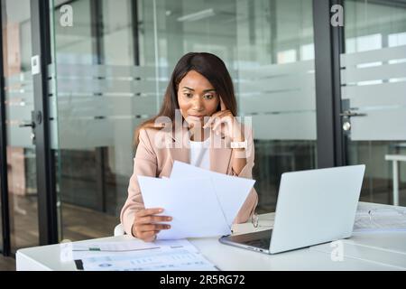 Donna d'affari seria account manager che controlla i documenti che lavorano in ufficio. Foto Stock