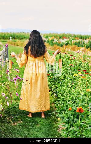 Donna spirituale che esegue meditazione guidata attraverso la musica utilizzando koshi chimes, vista posteriore Foto Stock