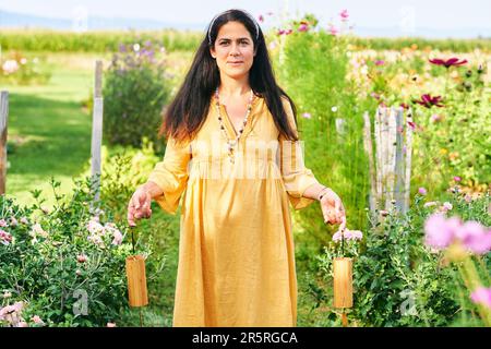 Donna spirituale che esegue meditazione guidata attraverso la musica utilizzando le chimes koshi Foto Stock