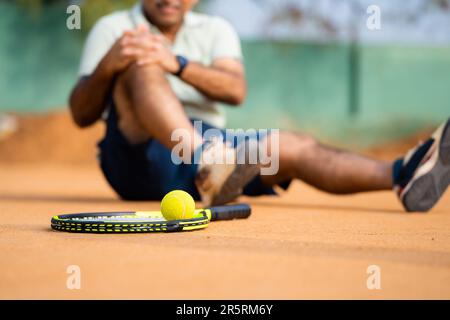 Primo piano tiro fuoco sul pallone, giocatore di tennis senior di mezza età ottenuto a causa della perdita di partita di tennis o di gioco durante la competizione - concetto di emergenza Foto Stock