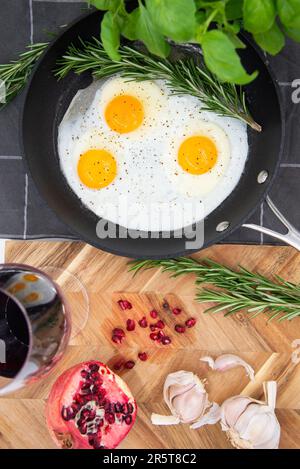 Una padella con una varietà di ingredienti tra cui uova e aglio è esposta su un tavolo Foto Stock