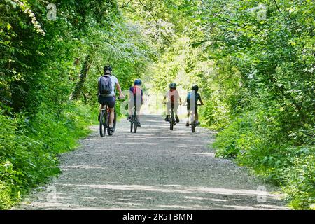 Un uomo, una donna e due bambini in bicicletta sul Settt Valley Trail, Derbyshire Foto Stock