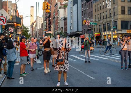 Gli amanti dell'astronomia rischiano la vita e l'arto mentre si trovano in West 23rd Street a Chelsea a New York per fotografare la prima notte del tramonto di Manhattanhenge lunedì 29 maggio 2023. Due volte all'anno, il sole si allinea al tramonto con la griglia della città e si trova al centro delle strade. L'evento, il nome coniato da Neil deGrasse Tyson del Planetario Hayden, si svolge 22 giorni prima e 21 giorni dopo il solstizio estivo a causa dell'angolo di 30 gradi della griglia della città, non è esattamente est-ovest-nord-sud. (© Richard B. Levine Foto Stock