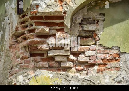 Sfondo di vecchio muro di mattoni gialli con intonaco collassato. Struttura della superficie dell'edificio intatta. Dove è una nicchia arcuata nella parete. Destro Foto Stock