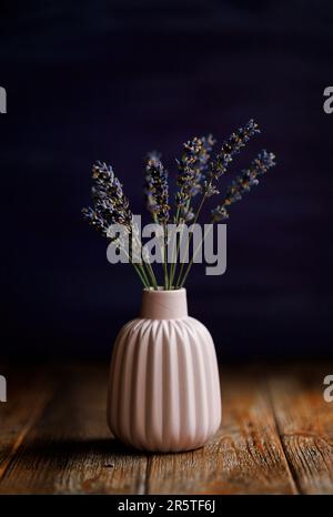 Bouquet di lavanda blu in un vaso in miniatura su un tavolo di legno naturale. Fermo-vita Foto Stock