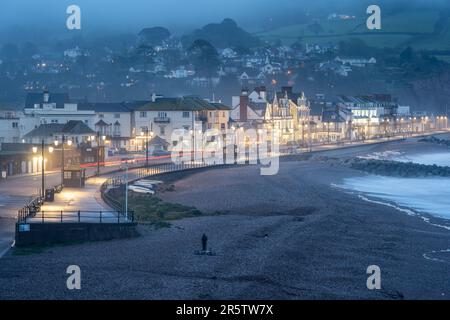 Il lungomare Esplanade è illuminato al crepuscolo nella città balneare di Sidmouth, sulla Jurassic Coast del Devon. Foto Stock
