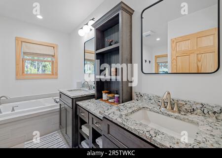 Un bagno interno dal design elegante con grande lavandino, vasca e lavandino Foto Stock