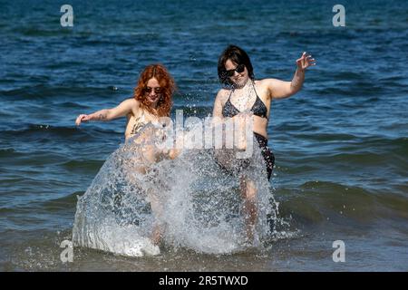 Victoria Shannon (a sinistra) e Jo Ballentine, da Belfast, giocano in mare a Helen's Bay a Bangor, Irlanda del Nord. Data immagine: Lunedì 5 giugno 2023. Foto Stock