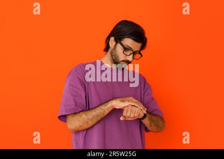 Ragazzo orientale che indossa occhiali per controllare l'ora sullo smartwatch Foto Stock