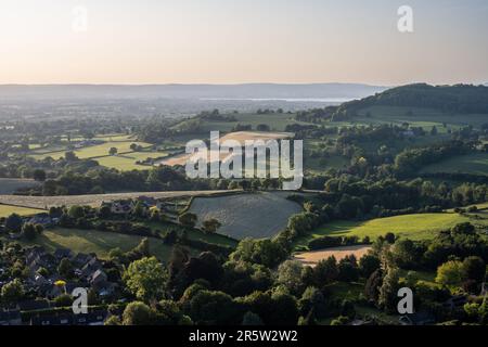 Il sole serale splende sul paesaggio pastorale della valle di Severn sotto il margine di Cotswolds a Nibley nord nel Gloucestershire, con l'estuario di Severn Foto Stock