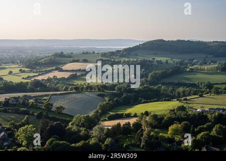 Il sole serale splende sul paesaggio pastorale della valle di Severn sotto il margine di Cotswolds a Nibley nord nel Gloucestershire, con l'estuario di Severn Foto Stock