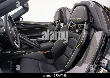 L'interno di un'auto sportiva con sedili in pelle nera e dettagli gialli Foto Stock
