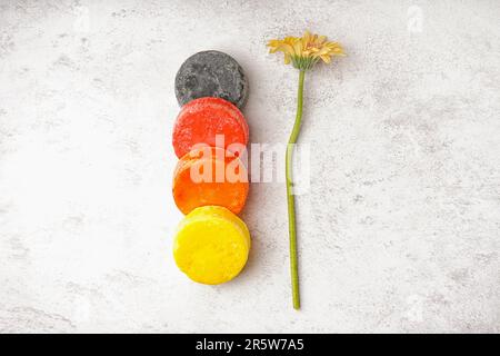 Diverso shampoo solido fatto a mano e fiore di calendula su sfondo chiaro Foto Stock