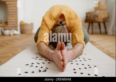 Uomo sportivo meditando da solo in casa appartamento Foto Stock