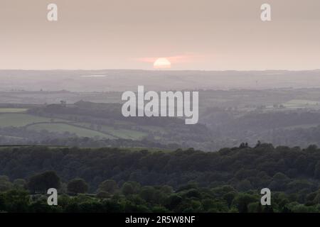Il sole tramonta sulle valli di Lyd e Tamar e sulle colline della Cornovaglia, come si vede dal Brent Tor nel Devon occidentale. Foto Stock