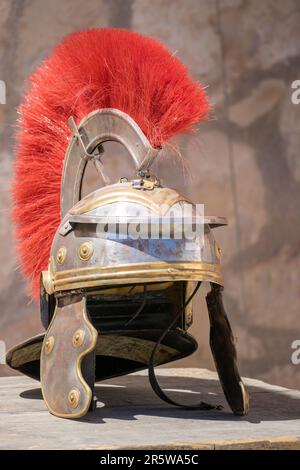 Vista verticale di un casco centurione romano con pennarelli rossi: Un casco militare romano, indossato da legioni dell'antico Impero Romano. Simbolo di potenza e st Foto Stock