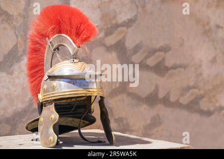 Vista orizzontale di un casco centurione romano con pennarelli rossi: Un casco militare romano, indossato da legioni dell'antico Impero Romano. Simbolo di potenza e. Foto Stock