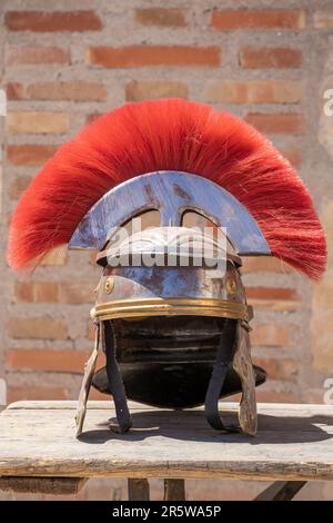 Vista verticale di un casco centurione romano con pennarelli rossi: Un casco militare romano, indossato da legioni dell'antico Impero Romano. Simbolo di potenza e st Foto Stock