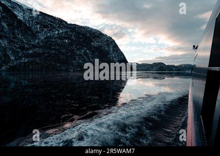 Un bellissimo scatto di un fiordo vicino alle scogliere da una finestra di una barca a Bergen, Norvegia Foto Stock