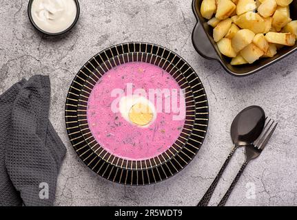 Fotografia alimentare di zuppa fredda di barbabietole, borscht, aneto, uova bollite, kefir, yogurt, panna, fritto, patate, verdure, sano, piatto, estate Foto Stock