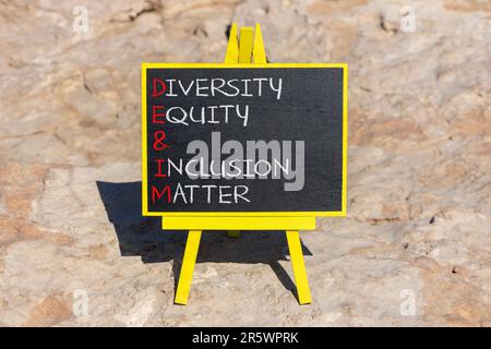 DEI Diversity equity Inclusion Matter Symbol. Concetto di parole DEI diversità equità e inclusione materia in lavagna. Splendido sfondo in pietra. Busin Foto Stock