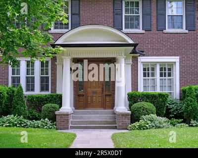 Tradizionale casa di mattoni a due piani con persiane in legno Foto Stock