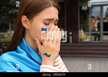 Triste giovane donna Ucraina con mani appese all'aperto. Spazio per il testo Foto Stock