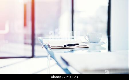 L'inizio di una giornata impegnativa. un diario giacente su un tavolo in un ufficio vuoto. Foto Stock