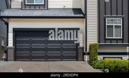 Porta del garage con vialetto di accesso a Vancouver, Canada. Porta garage in casa di lusso. Foto di strada, nessuno, fuoco selettivo Foto Stock