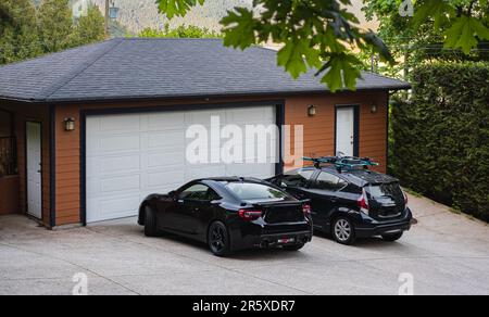 Porta del garage con ampio vialetto di accesso a Vancouver, Canada. Porta garage in casa di lusso. Foto di strada, nessuno, fuoco selettivo Foto Stock