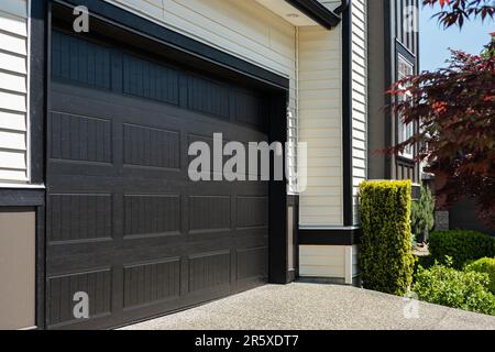 Porta del garage con vialetto di accesso a Vancouver, Canada. Porta garage in casa di lusso. Foto di strada, nessuno, fuoco selettivo Foto Stock