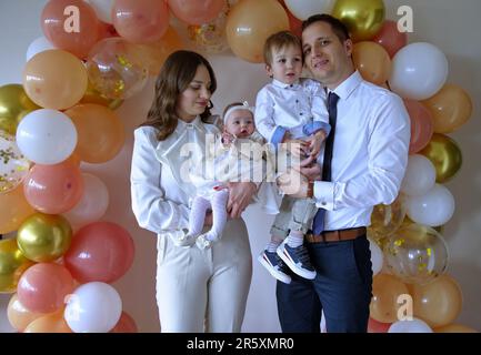 Giovane famiglia che celebra il battesimo della bambina Foto Stock