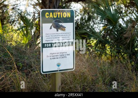 Alligatori segnale di avvertimento nel parco statale della Florida per la prudenza e la sicurezza durante il percorso a piedi Foto Stock