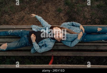 Felice giovane coppia amorevole giovane rilassarsi sulla panchina nel parco Foto Stock
