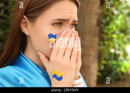 Emotiva giovane donna Ucraina con mani appese all'aperto, primo piano. Spazio per il testo Foto Stock