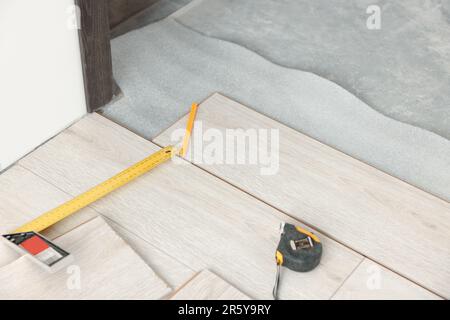 Tavole di parquet sul pavimento e utensili in camera preparati per la ristrutturazione Foto Stock