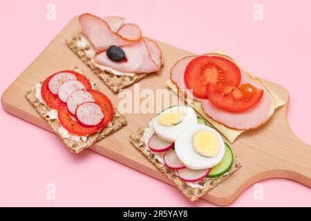 Diversi tipi di pane integrale con Prato, pomodoro, Rasth, cetriolo e formaggio. Colazione facile. Dieta alimentare. Panini veloci e sani. Croccante con gustoso ripieno. Snack dietetico sano Foto Stock