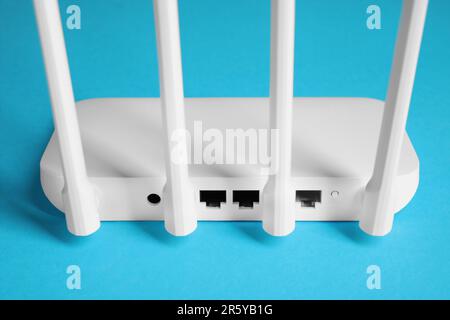 Nuovo router Wi-Fi bianco su sfondo blu, vista posteriore Foto Stock