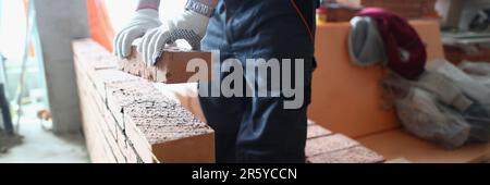 Costruzione muratore costruisce muro di mattoni in appartamento Foto Stock
