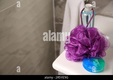 Soffio doccia viola e prodotti cosmetici sul lavandino in bagno, spazio per il testo Foto Stock