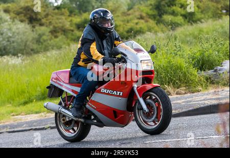 Stony Stratford,UK - Giugno 4th 2023: 1990 Red DUCATI 750 Classic moto in viaggio su una strada di campagna inglese. Foto Stock