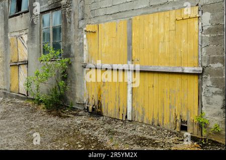 vecchie porte anteriori e vetro nel muro di mattoni Foto Stock