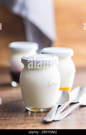 Yogurt bianco in vaso sul tavolo di legno. Foto Stock