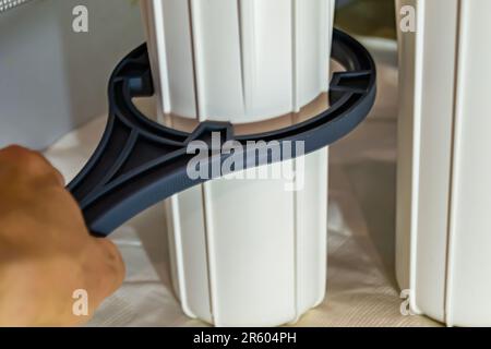 Fotografia a tema cartuccia filtro acqua per la casa su sfondo cucina, foto che consiste nell'installazione cartuccia filtro acqua a casa, sostituzione Foto Stock