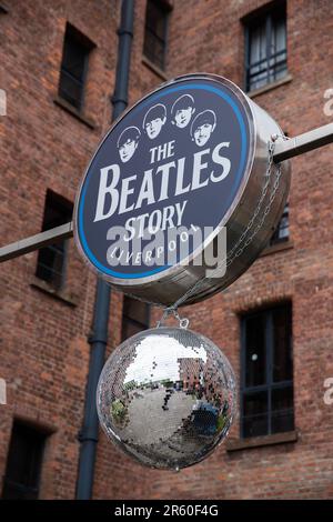 Il segno "The Beatles Story" e la palla di scintilla, appesi all'esterno dell'attrazione turistica del Royal Albert Dock, Liverpool. Inghilterra. Foto Stock