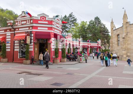 Kislovodsk, Russia - 9 maggio 2023: Vista sulla strada con il negozio centrale e caffetteria, gente comune a piedi la strada in una giornata nuvolosa Foto Stock